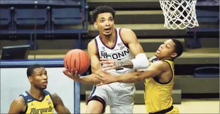  ?? David Butler II / USA Today Sports ?? UConn guard James Bouknight is fouled by Marquette guard Greg Elliott, right, in Saturday’s game at Gampel Pavilion in Storrs.