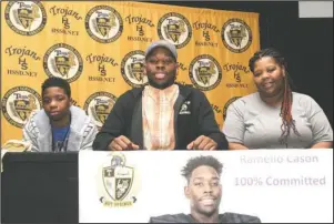  ?? The Sentinel-Record/Richard Rasmussen ?? TROJAN TIGER: Hot Springs senior Ramello Cason, center, was joined by family member Marcell Kelley, left, and his mother, Sharrita Cason, Wednesday on stage at the Johnnie Mae Mackey Theatre to sign to play football for Ouachita Baptist.