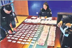  ?? PROVIDED TO CHINA DAILY ?? Railway police in Lhasa, capital of the Tibet autonomous region, sort train tickets, cash and computers seized during crackdown on digital scalpers.