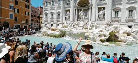  ?? Foto: Gregorio Borgia, dpa ?? Soll Glück bringen: der Wurf einer Geldmünze in den Trevi-Brunnen in Rom.