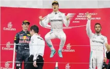  ?? Picture / AP ?? Nico Rosberg ( centre) jumps for joy after winning in Japan but Lewis Hamilton ( right) and Max Verstappen are less enthusiast­ic.