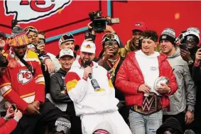 ?? Jay Biggerstaf­f/Getty Images ?? The Kansas City Chiefs’ Travis Kelce, with microphone, and Patrick Mahomes celebrate on stage with teammates during the Super Bowl 57 victory parade on Wednesday in Kansas City, Mo.