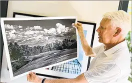  ?? Sam Farmer Los Angeles Times ?? JOHN LIGHT, holding up his black-and-white photo of No. 16, has made L.A. Country Club’s landscape his passion and calls it “one of the great gems of golf.”