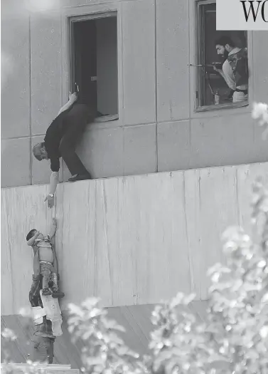  ?? OMID VAHABZADEH / AFP / GETTY IMAGES ?? Iranian policemen evacuate a child from the parliament building in Tehran during an attack Wednesday on the complex. The Islamic State group took responsibi­lity for the attacks by gunmen and suicide bombers, its first in Iran.