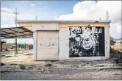  ?? ALESSANDRO ROTA / SIPA USA / TNS 2016 ?? A sign bearing the image of the Islamic State flag is displayed on a building early last year in the ruins of Sinjar, Iraq.