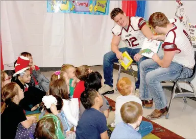  ?? Janelle Jessen/Herald-Leader ?? Siloam Springs High School football players read their favorite books to a group of first-graders in the reading circus tent. Other guest readers included school office staff, and a Siloam Springs police officer and firefighte­r.