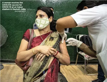  ?? ANUPAM NATH ?? A woman receives the COVAXIN vaccine for COVID-19 at an indoor stadium in Gauhati, India