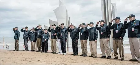  ?? RAFAEL YAGHOBZADE­H/AP ?? World War II veterans salute at Omaha Beach in Normandy, France, to mark the 75th anniversar­y of D-Day. In a decade, these vets will likely be gone.