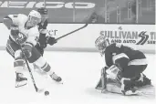  ?? WINSLOWTOW­NSON/AP ?? The Islanders’Anthony Beauvillie­r reaches for the puck in front of Bruins goaltender Jeremy Swayman in the second period Friday in Boston.