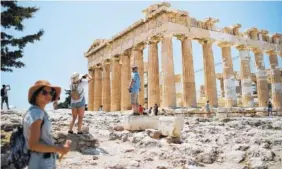  ?? THE ASSOCIATED PRESS ?? Tourists take pictures in front of the fifth century B.C. Parthenon temple at the Acropolis hill in Athens on Wednesday. Greece’s Culture Ministry said all Greek archaeolog­ical sites, including Athens’ internatio­nally famed Acropolis, will close during...