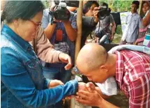  ??  ?? RINDU BUNDA: Nur Hamdan, anak ketiga Parinah, menyambut sang ibu di Cilacap kemarin (12/4). Foto kanan, Parinah (memakai jaket jins) memeluk erat anak pertamanya, Sunarti.