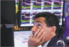  ?? Richard Drew / Associated Press ?? Specialist Peter Mazza works at his post on the floor of the New York Stock Exchange. The Dow Jones industrial average fell nearly 400 points Monday.