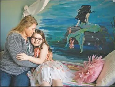  ??  ?? Mary Jane poses with her grandmothe­r Linda Soli at her home. “My favorite thing is the mermaid picture on the wall because it’s a mermaid and I love it,” Mary Jane said. “It’s shiny and bright.”