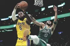  ?? AP PHOTO/MICHAEL DWYER ?? Los Angeles Lakers’ LeBron James (6) and Boston Celtics’ Jayson Tatum (0) battle for a rebound during the first half of an NBA basketball game on Friday in Boston.