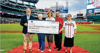  ?? COURTESY OF KEVIN LILES/ATLANTA BRAVES ?? Braves Foundation President and CEO Mike Plant (from left) presents a $50,000 check to Cobb Veterans Memorial Foundation President Donna Rowe, Vice President Shelley O’malley, board member U.S. Air Force Maj. Gen. Curtis Williams and Cobb County Commission­er Joann Birrell.