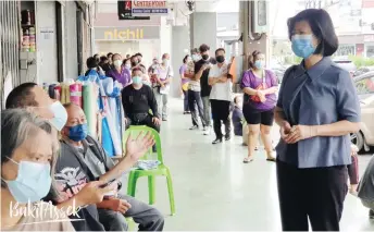  ??  ?? Handout photo shows Chang speaking to a welfare recipient in front of BSN Sibu.