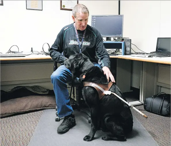  ?? TROY FLEECE ?? SaskTel employee Shan Noyes at work with his guide dog, Danson. The eight-year-old canine has made a huge difference for the Regina man — on and off the job.
