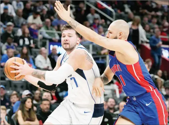  ?? ?? Dallas Mavericks guard Luka Doncic (77) is defended by Detroit Pistons guard Evan Fournier during the second half of an NBA basketball game, Saturday, March 9, 2024, in Detroit. (AP)