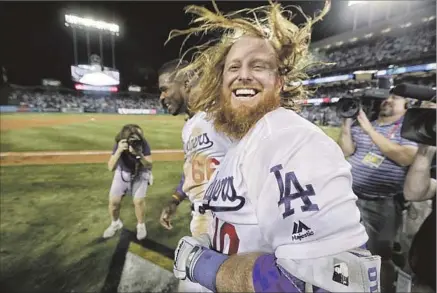  ?? Robert Gauthier Los Angeles Times ?? JUSTIN TURNER, along with Yasiel Puig (66), savors hitting a walk-off three-run homer to lift the Dodgers over the Chicago Cubs.