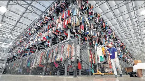  ?? MATT YORK/AP PHOTOS ?? Thousands of garments are stored on a three-tiered conveyor system at the ThredUp sorting facility in Phoenix