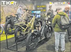  ?? C. Douglas Nielsen ?? Attendees at the 2023 Shooting, Hunting and Outdoor Trade Show inspect bikes powered by electric motors that offer a quiet alternativ­e to negotiatin­g the woods.