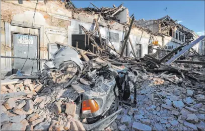  ?? The Associated Press ?? A car is covered by debris Tuesday after an earthquake in Petrinja, Croatia. The quake caused several deaths and major damage.