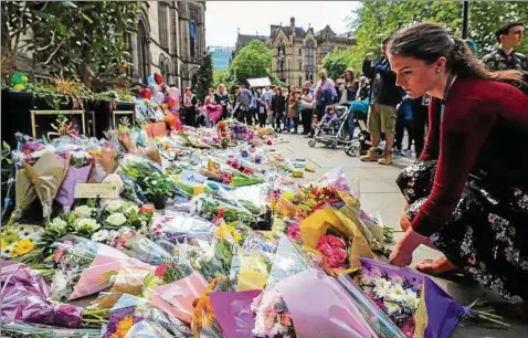  ??  ?? Stille Trauer: Menschen legen vor dem Rathaus am Albert Square Blumen für die Opfer ab. Foto: Peter Byrne/dpa