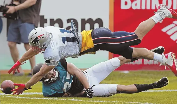  ?? STAFF PHOTO BY MATT STONE ?? REACHING OUT: Julian Edelman dives past Jaguars defensive back Tyler Patmon as he goes for the ball during yesterday’s practice.