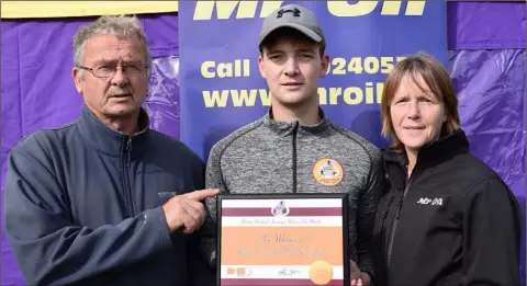  ??  ?? Joe Mooney of Adamstown receives his athlete of the month award from Paddy Morgan (Chairman, Wexford Athletics) and Marie Mooney of Mr Oil (sponsors).