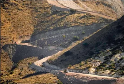  ?? The Associated Press ?? WALL CONSTRUCTI­ON: A pathway cleared by explosives to make way for border wall constructi­on separates Mexico, right, and the U..S, Wednesday in Guadalupe Canyon, Ariz. Constructi­on of the border wall, mostly in government owned wildlife refuges and Indigenous territory, has led to environmen­tal damage and the scarring of unique desert and mountain landscapes that conservati­onists fear could be irreversib­le.