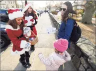 ?? Matthew Brown / Hearst Connecticu­t Media file photo ?? Bianca Lupinacei and Vanessa Hincapie, dressed up in Holiday fashion, pass out candy canes and flyers for Sophia’s during the 11th annual Holiday Stroll in Greenwich on Dec. 7, 2019.