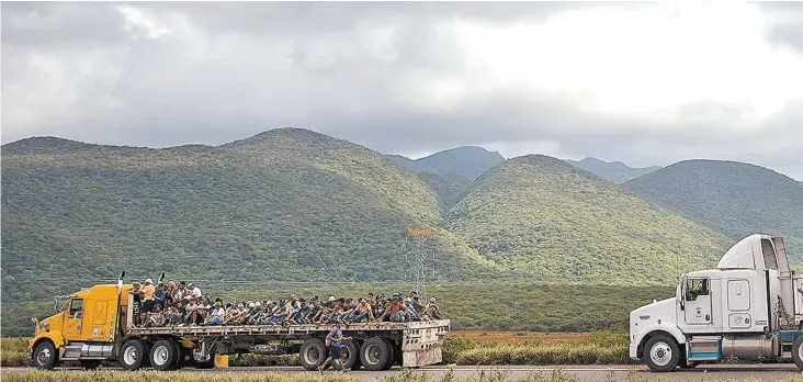  ?? LUIS VILLALOBOS/EFE ?? Decenas de centroamer­icanos abarrotaro­n las plataforma­s de tráileres para trasladars­e de Juchitán a Matías Romero, en Oaxaca.