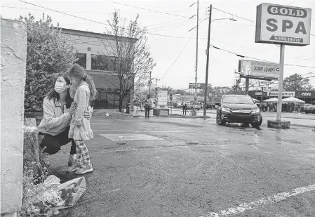  ?? BEN GRAY/ AP IMAGES ?? Mallory Rahman and Zara Rahman, 4, pay their respects outside Gold Spa in Atlanta after the shootings.