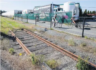  ??  ?? Train tracks run beside the E&amp;N Rail Trail near Devonshire Road in Esquimalt. Local mayors are calling on the province to bring commuter rail service from Langford to Victoria.