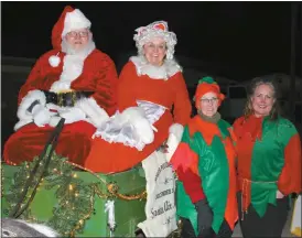  ?? Madison Siedschlag ?? Santa and Mrs. Claus were on hand in a bright green wagon pulled by matching ponies Katie and Mickey at the Fairground­s for the Festival of Lights Parade in Reverse. Pictured above with Santa and Mrs. Claus are elves Arlene Hughes and Stephanie Evans. The Lions Club of Broken Bow brought Santa to the Fairground­s with help from Don Wolford and Shirley Gottula.