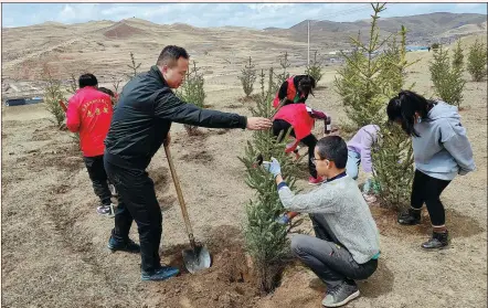  ?? PROVIDED TO CHINA DAILY ?? Min Shengcai (center) and volunteers plant trees in Lintan county, Gansu province.