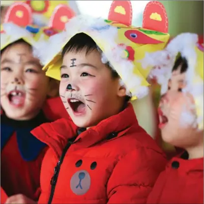  ?? XINHUA ?? Children wear tiger-head hats and have the character wang (“king”) written on their foreheads to celebrate the Year of the Tiger in Deqing county, Huzhou city, Zhejiang province.
