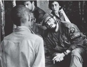  ?? AP ?? In this 1958 file photo, Cuba’s leader ‘Fidel Castro’ questions a man charged with banditry, as Celia Sanchez, Castro’s confidante and closest friend before dying of cancer in 1980, looks on during a trial held in the guerrillas’ base in the Cuban...