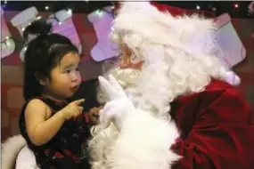  ?? MARK THIESSEN — THE ASSOCIATED PRESS ?? This photo shows Caasi Lockwood sits on Santa’s lap in Saint Michael, Alaska, a remote island community off the state’s western coast in the Bering Strait.