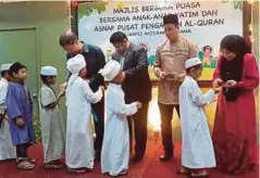  ??  ?? ANAK yatim, asnaf dan saudara baru menerima sumbangan duit raya.