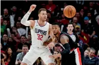  ?? — AP ?? Los Angeles Clippers forward Blake Griffin is defended by Portland Trail Blazers guard Damian Lillard.