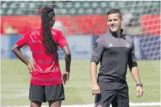  ?? JASON FRANSON/THE CANADIAN
PRESS ?? Canada’s head coach John Herdman and Kadeisha Buchanan chat during a practice session. Canada received a favourable draw Monday in its road to the Olympic women’s soccer tournament.