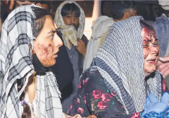  ??  ?? Wounded women arrive at a hospital for treatment after being injured in one of two bomb blasts that killed scores in Kabul.