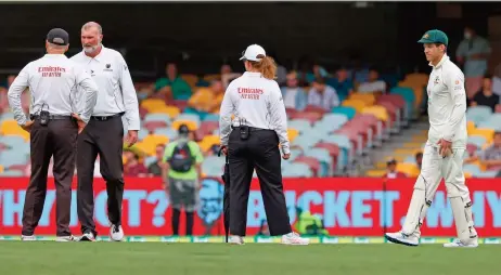  ?? (AFP) ?? Australia's captain Tim Paine (right) and the umpires examine the pitch area after rain on day two of the fourth Test against India at The Gabba in Brisbane on Saturday