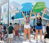  ?? MIKE STOCKER/SOUTH FLORIDA SUN SENTINEL ?? Holly Mackinder, a bartender at Blondies, and Jessica Dawkins, a bartender at the Elbo Room, join a “Right to Work” rally on Tuesday for bars that are still not allowed to open at the Elbo Room on Fort Lauderdale beach.