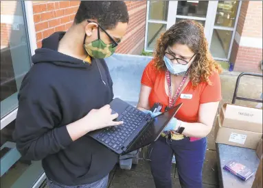  ?? Ned Gerard / Hearst Connecticu­t Media ?? Teacher Ana Batista helps eighth-grader Jelson Martinez with a new computer at Cesar Batalla School in Bridgeport on May 15.