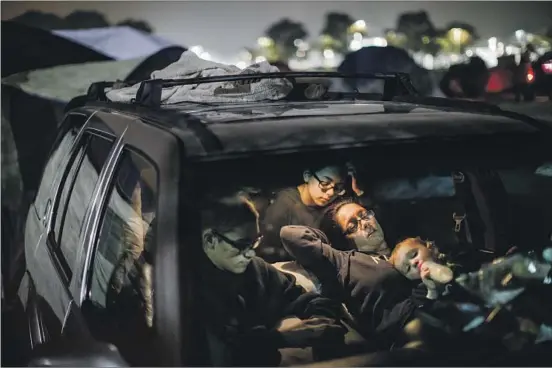  ?? Marcus Yam Los Angeles Times ?? MEMBERS of the Hardin family prepare to sleep Thursday in their vehicle in a Walmart parking lot in Chico, where many evacuees sought refuge after the fire.