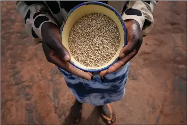  ?? (AP/Tsvangiray­i Mukwazhi) ?? Chagwena holds a plate with millet grains Jan. 18 outside her house.