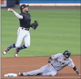  ?? MARTA LAVANDIER — THE ASSOCIATED PRESS ?? Marlins second baseman
Jazz Chisholm Jr. throwsto first base for the double playasthe Giants’ Wilmer Flores slides into second base during the second inning on Friday in Miami.