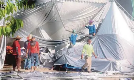  ?? PIC BY AMRAN HAMID ?? Workers clearing debris at the Kedah Pas Complex in Alor Star yesterday.